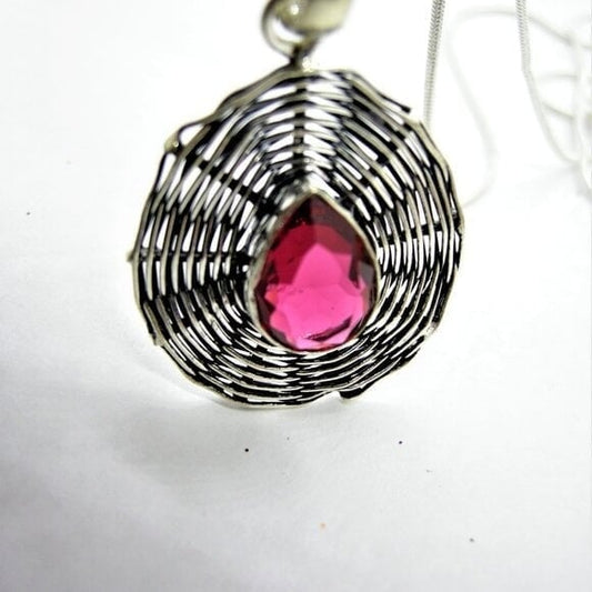 Chrome silver spiderweb pendant with dark pink topaz